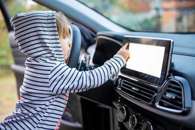 Barn som leker med infotainment system i bil